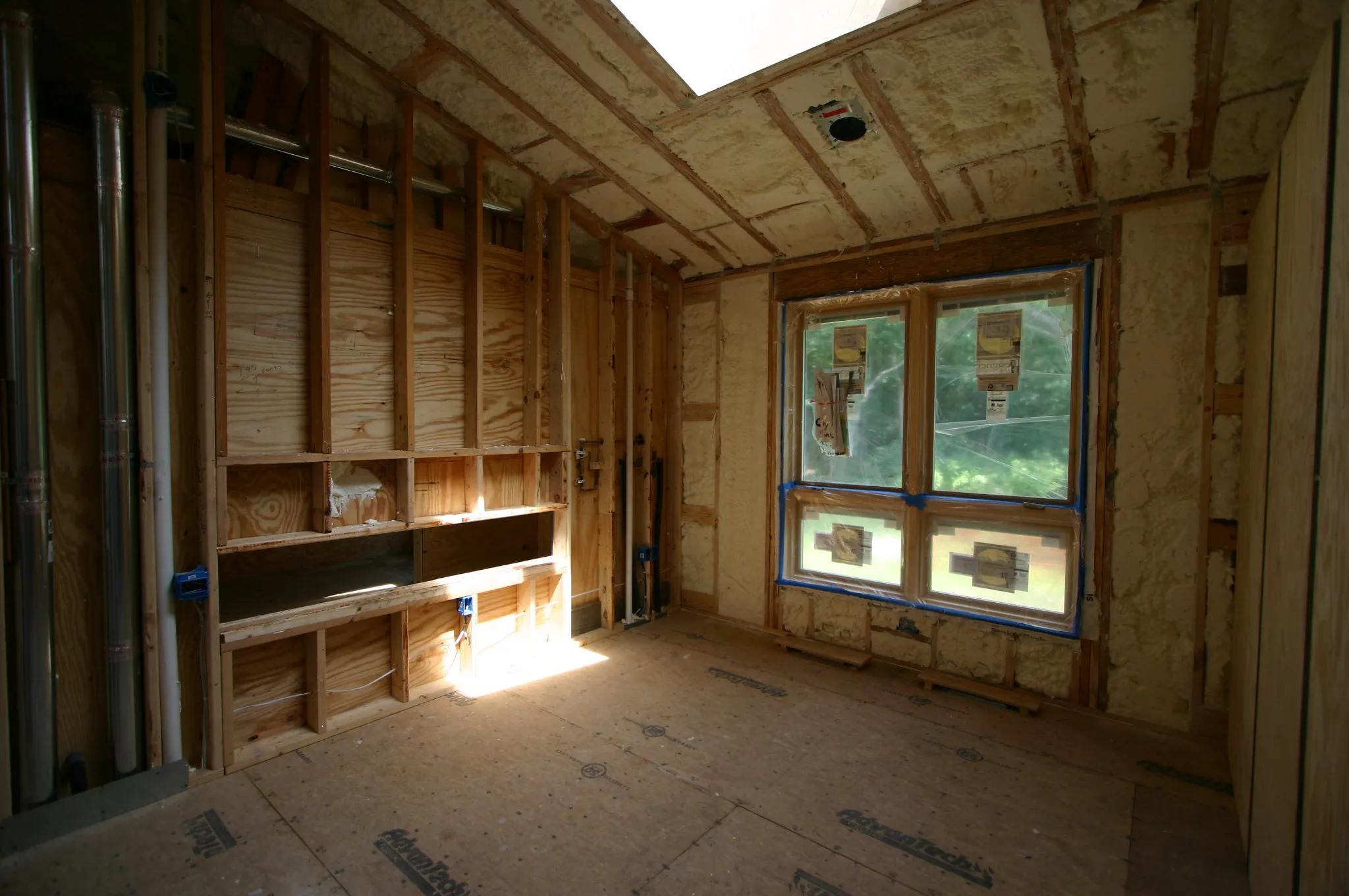 New construction room with spray foam on ceiling and walls