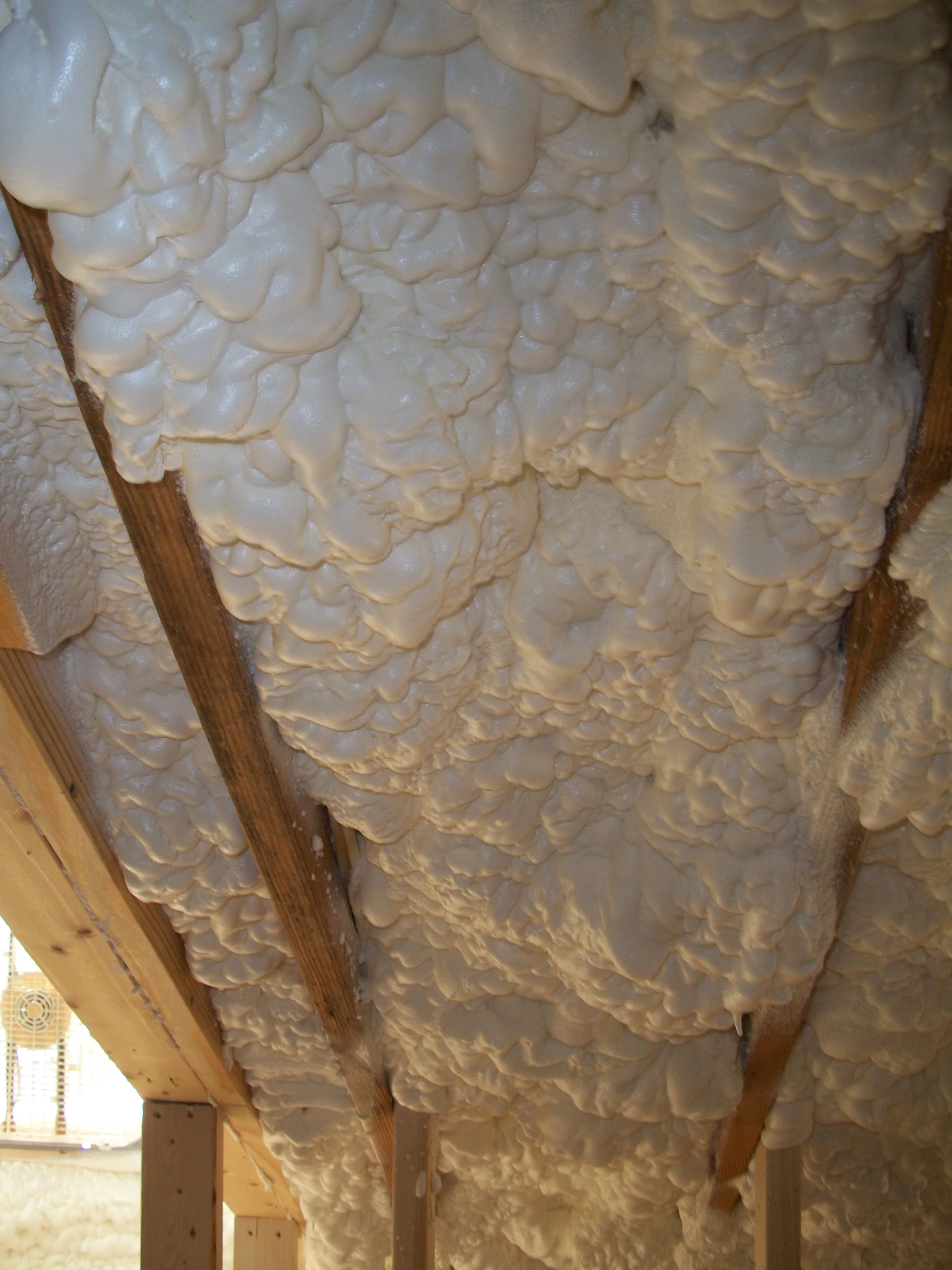 Close-up of open-cell foam between rafters