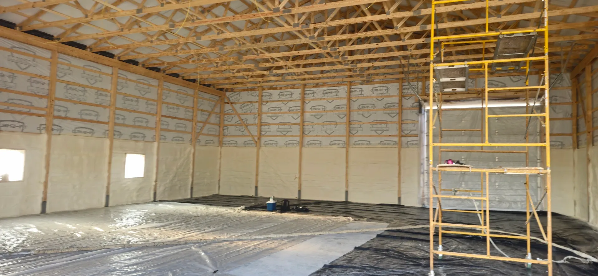 Pole barn walls with scaffolding during spray foam application